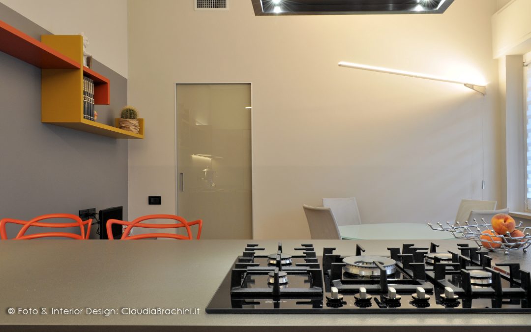 cucina grigio in vetro con particolari arancio