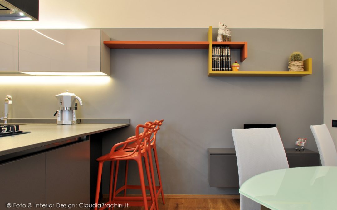 cucina grigia in vetro con particolari arancio