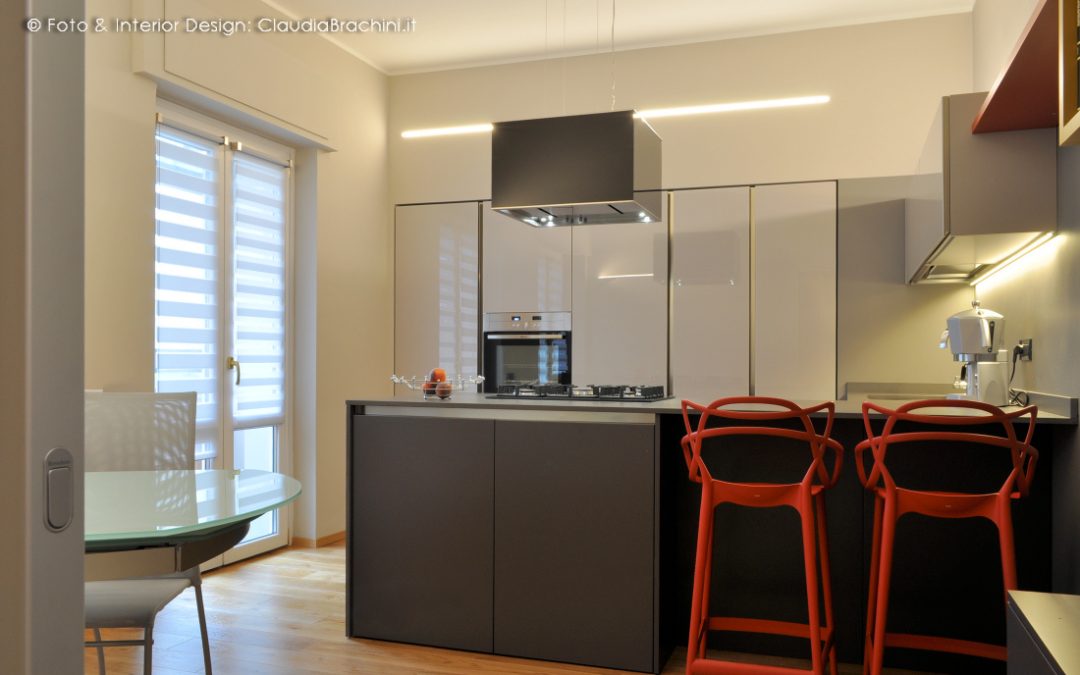 cucina grigia in vetro con penisola e colonne incassate