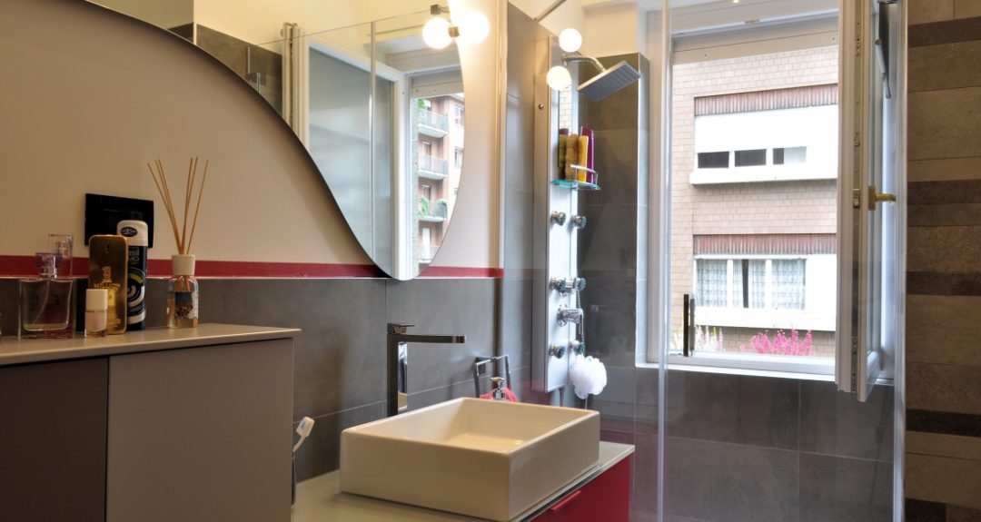 bagno grigio e fucsia con doccia vicino alla finestra
