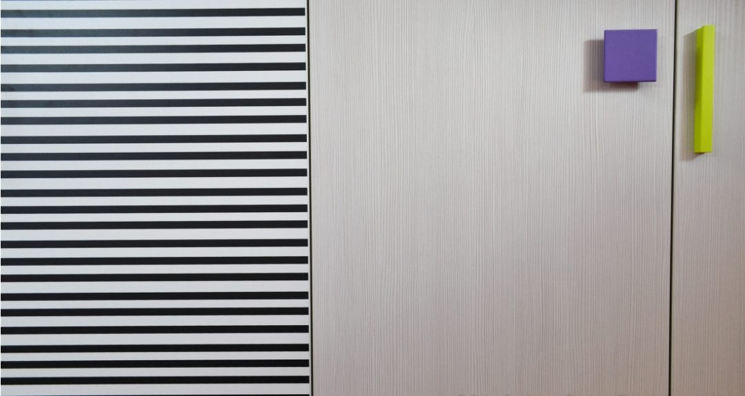 particolare armadio con strisce e maniglie colorate