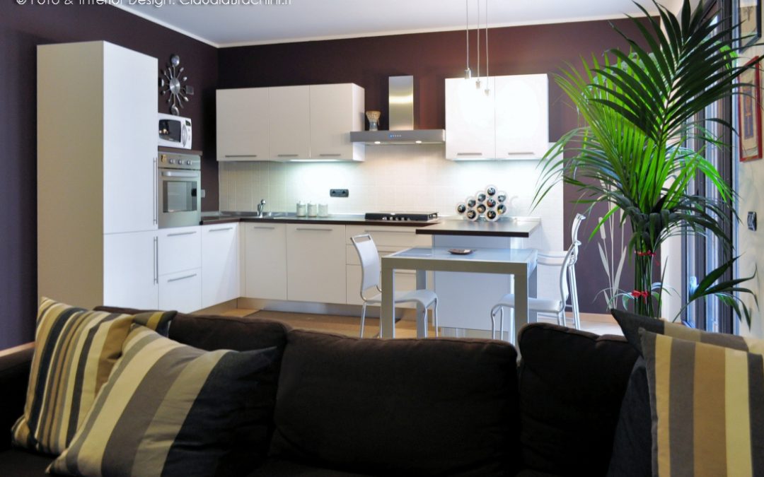 soggiorno living cucina bianca con penisola e parete cacao