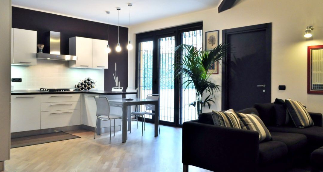 soggiorno living cucina bianca e parete cacao