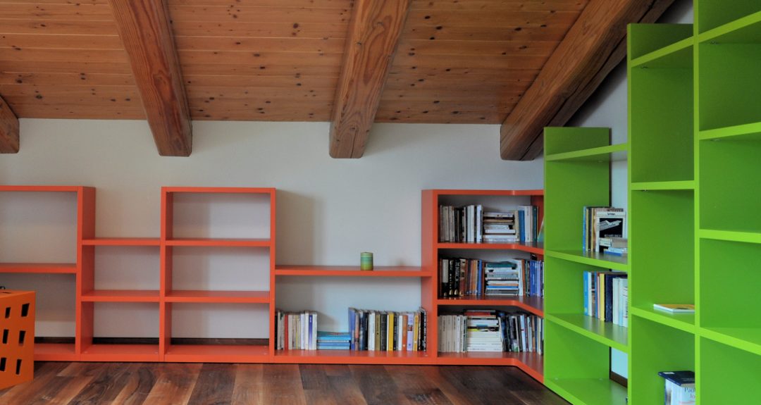 libreria a gradoni arancio e verde in mansarda