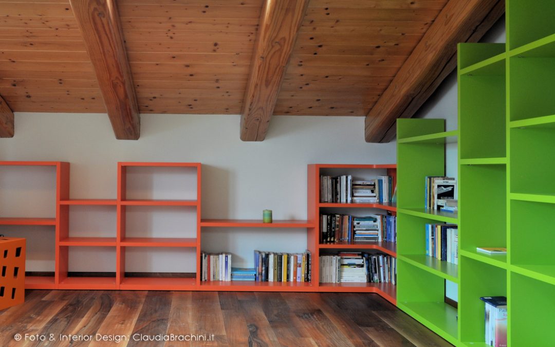 libreria a gradoni arancio e verde in mansarda