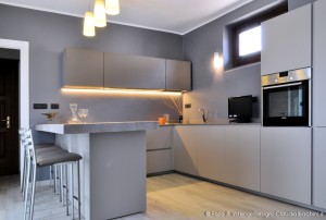 cucina tortora con grande penisola in legno e resina di cemento