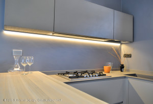 cucina tortora con grande penisola in legno e resina di cemento