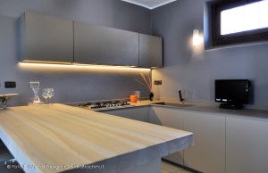 cucina tortora con grande penisola in legno e resina di cemento
