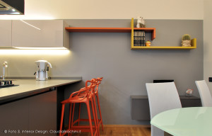 cucina grigia in vetro con particolari arancio grande penisola con sgabelli